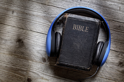 Holy Bible and headphones concept for modern religious education, podcast or help with hearing for blind studying